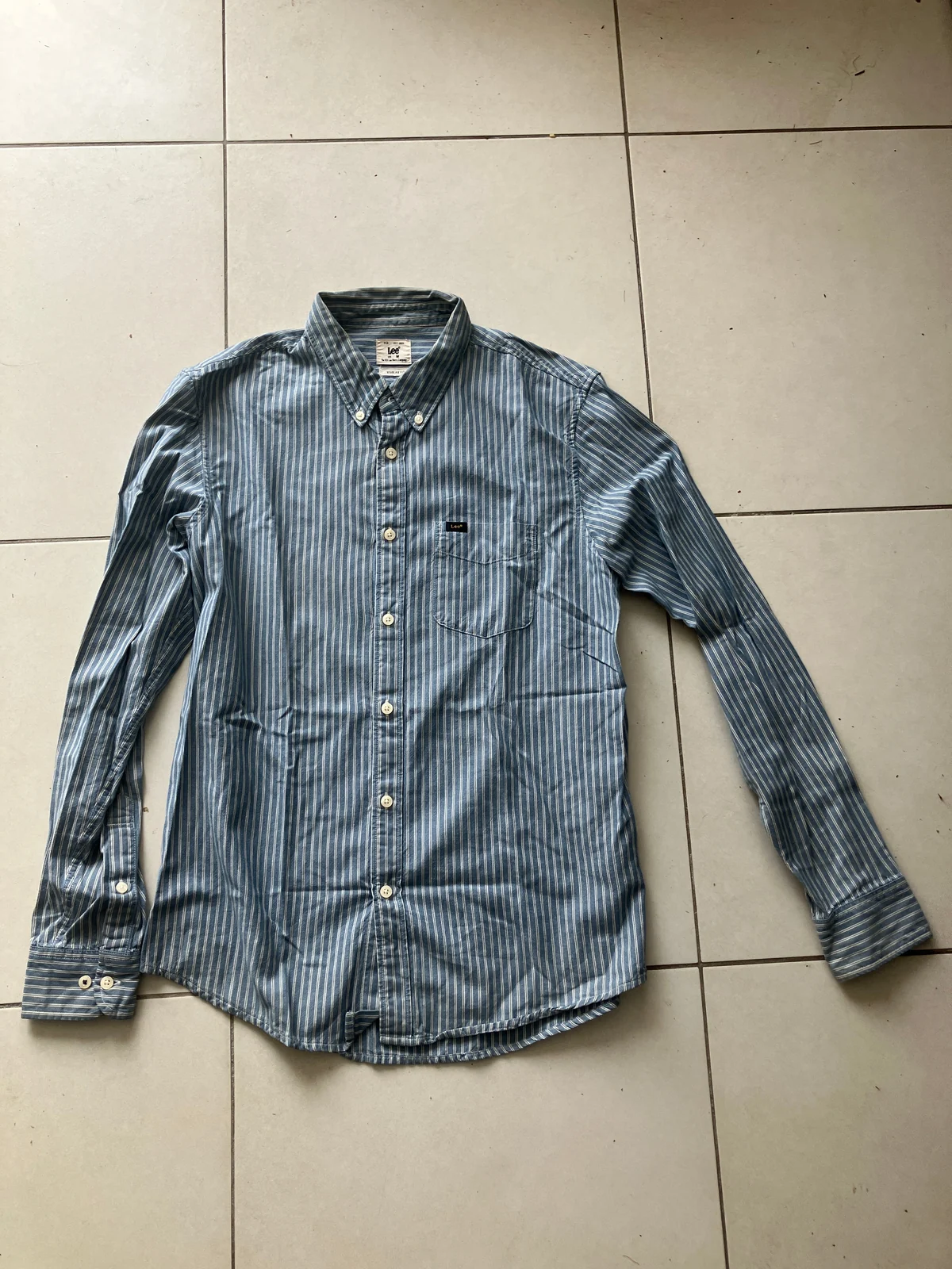 Original striped button-down shirt photographed on a tiled floor